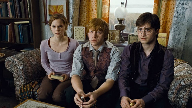 En esta imagen aparece Harry Ron y hermione sentados en un sofá